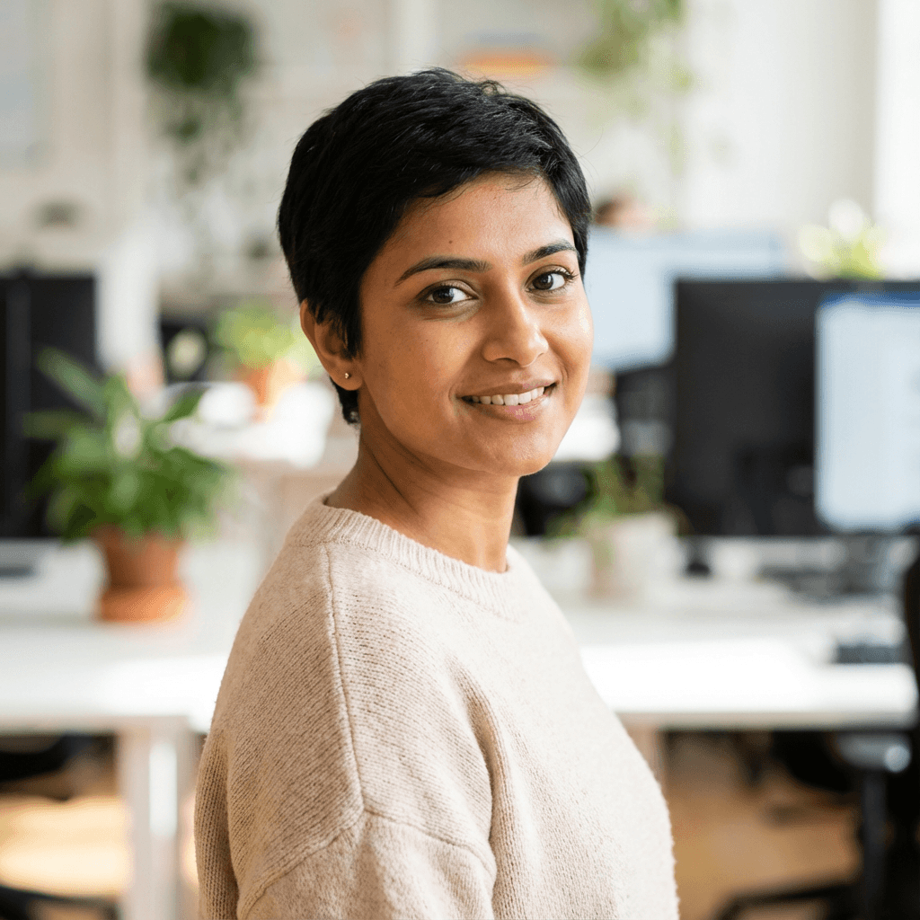 Female cybersecurity investigator in her early 30s, South Asian, warm but focused expression